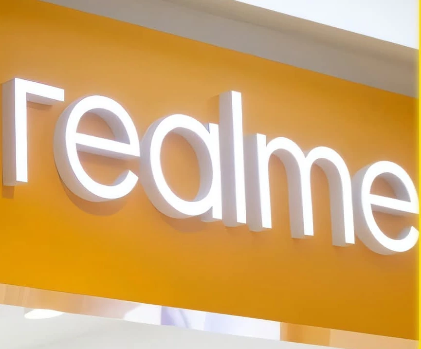 حروف مضيئة بيضاء لشعار realme على واجهة صفراء
