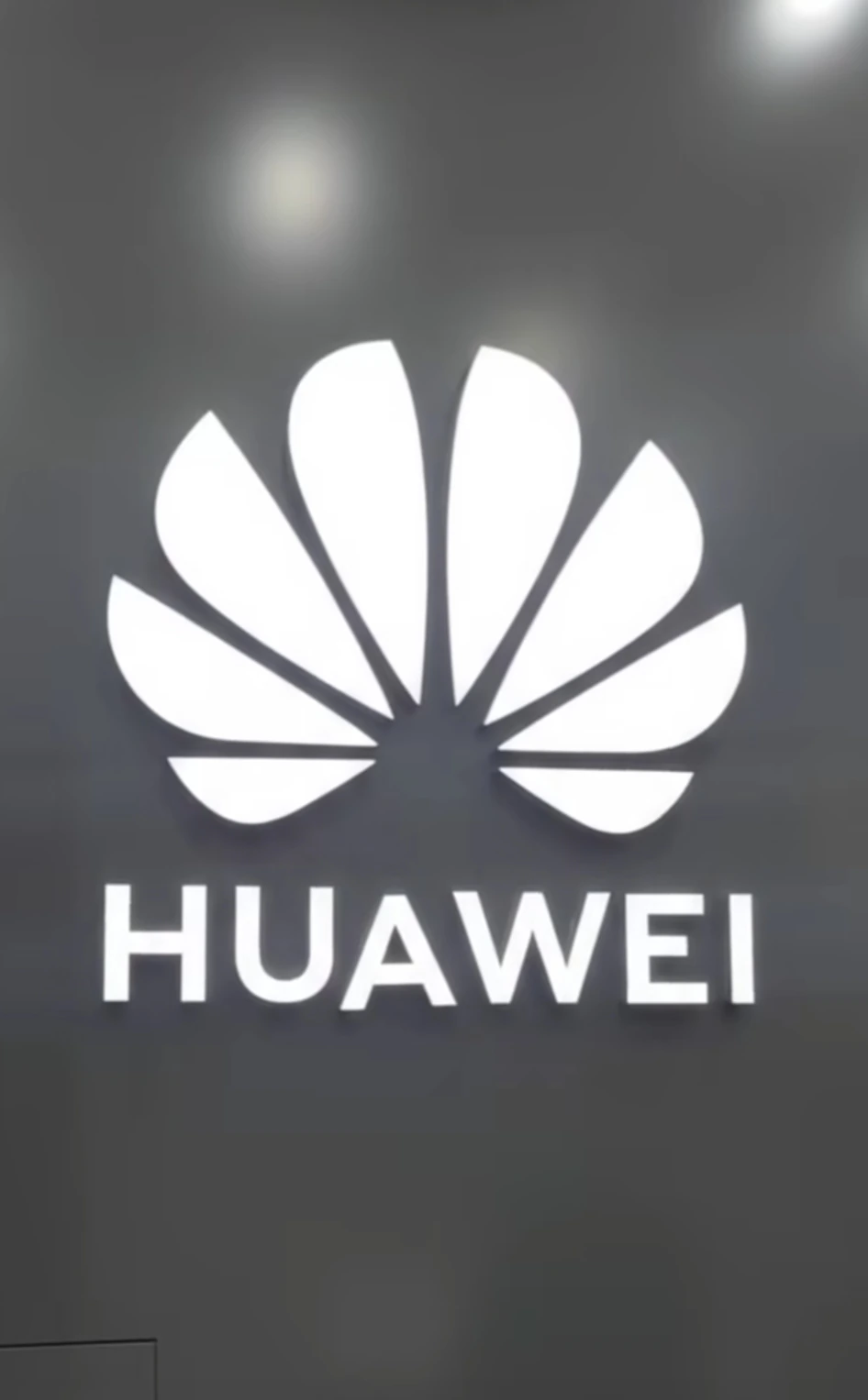شعار HUAWEI مضيء باللون الأبيض على خلفية داكنة