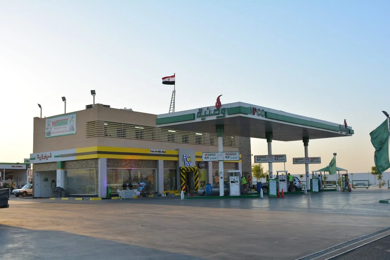 محطة وقود في ضوء النهار مع الواجهات واللوحات الإعلانية